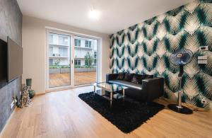 a living room with a couch and a large window at In Apartments in Brno