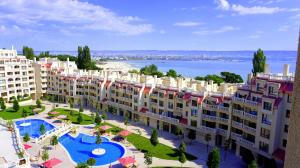 Cette chambre offre une vue sur un grand bâtiment doté d'une piscine. dans l'établissement Апартаменти Варна Саут на плажа - Varna South Apartments on the beach, à Varna