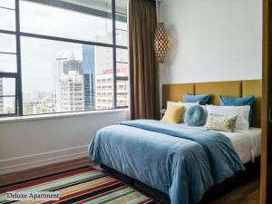 ein Schlafzimmer mit einem Bett und einem großen Fenster in der Unterkunft Private apartments in a Landmark Heritage Building in Auckland + 34 Fotos