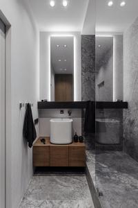 a bathroom with a white sink and a shower at At Home Apartment in Odesa +29 photos