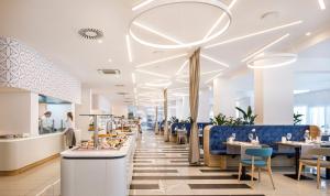 a restaurant with blue chairs and tables and a cafeteria at Valamar Carolina Hotel & Villas in Rab