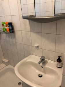 a white bathroom with a sink and a toilet at Apartment Essen Holsterhausen in Essen