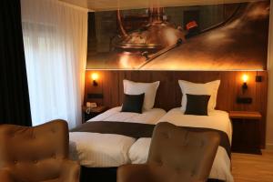 ein Hotelzimmer mit 2 Betten und 2 Stühlen in der Unterkunft Hotel Botteltje in Ostende