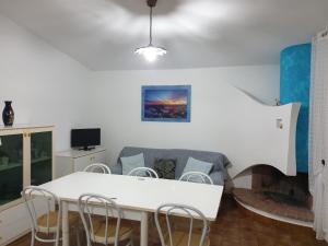 カーラゴノネにあるCasa Lucianoのリビングルーム(白いテーブル、椅子付)