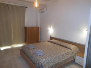een slaapkamer met een bed met twee handdoeken erop bij La Rosa dei Venti in Teulada