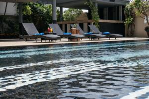 un grupo de sillas sentadas junto a una piscina en Witz Bangkok Ramkhamhaeng en Bangkok