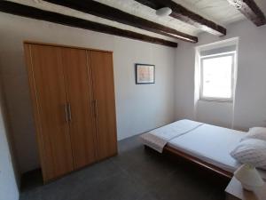 1 dormitorio con 1 cama y armario de madera en Apartment Rino en Rijeka