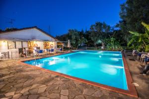 a swimming pool in a resort at night at Camping & Rooms Kariotes in Lygia