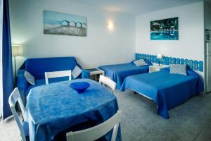um quarto com duas camas, um sofá e uma mesa em Comodoro Estudio Vista Mar Explotaciones Ravel em Arona
