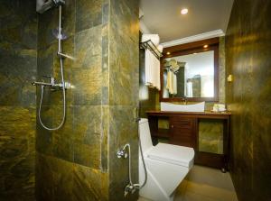 een badkamer met een douche, een toilet en een wastafel bij Galaxy Grand Hotel in Nuwara Eliya