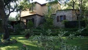 una casa de piedra con un jardín delante de ella en Le Sughere, en Padru