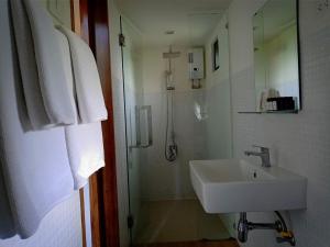 a white bathroom with a sink and a shower at The Birder's Lodge Khao Yai in Pak Chong +72 photos