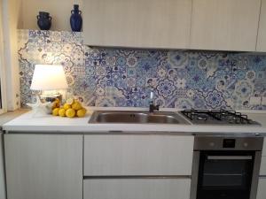 a kitchen with a sink and a lamp on a counter at Mediterranean Apartments in Capo dʼOrlando