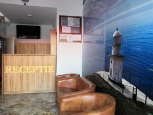 a waiting room with leather chairs and a lighthouse at Hotel Prestige Beach in Costinesti