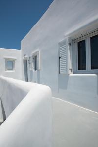 a white building with windows on the side of it at Bleland Mykonos II in Ano Mera