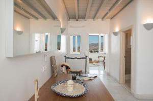 a living room with a table and some windows at Bleland Mykonos II in Ano Mera