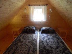 Bett in einem Holzzimmer mit Fenster in der Unterkunft Haaviku Nature Cottage in Tepelvälja