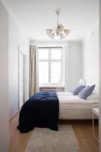 a bedroom with a bed and a window and a chandelier at 2ndhomes Gorgeous 2BR apartment by the Esplanade Park in Helsinki