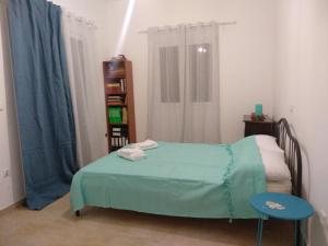 a bedroom with a green bed and a book shelf at Kymi Bay House in Platána