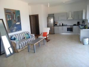 ein Wohnzimmer mit einem Sofa und einer Küche in der Unterkunft Kymi Bay House in Platána