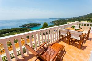 balcón con mesa, sillas y vistas al océano en Syvota Sunset Apartments, en Perdika