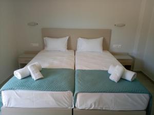 two beds in a bedroom with towels on them at Niko Elen in Stalida