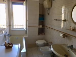 ein Badezimmer mit einem Waschbecken, einem WC und einer Badewanne in der Unterkunft Casa Francesca in Badolato