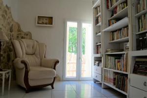 uma sala de estar com uma cadeira e prateleiras de livros em Gîte **** "le refuge des fées" em Saint-Julien-du-Gua