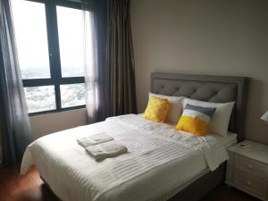 ein Schlafzimmer mit einem großen Bett mit gelben und blauen Kissen in der Unterkunft Studio Apartment with Balcony by Host Assist i-City in Shah Alam