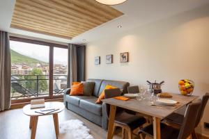 a living room with a couch and a table at Résidence Daria-I Nor by les Etincelles in L'Alpe-d'Huez