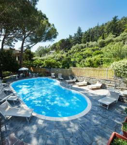 a large swimming pool with chairs and a patio at Hotel Villa Adriana in Monterosso al Mare