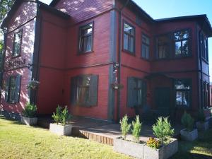 a red house with plants in front of it at Villa Victoria in Ventspils