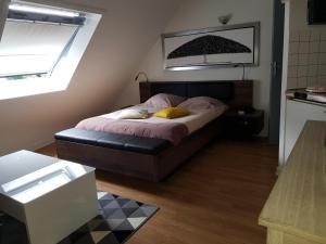 een slaapkamer met een bed met 2 kussens erop bij Les Locations du Puits in Rochefort-en-Terre