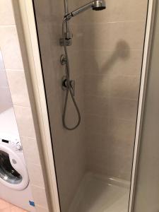 una doccia con porta in vetro in bagno di Al Faro a Grado