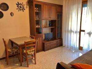 a living room with a table and a television at Al Faro in Grado