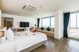 a hotel room with a large bed and a couch at Rattanachol Hotel in Chon Buri