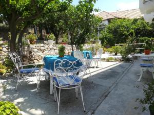 una mesa y sillas al aire libre con una mesa y sillas azules en Pythaïs Hotel, en Pythagoreio