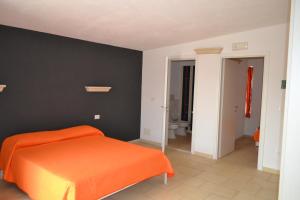 a bedroom with an orange bed and a black wall at Masseria Romagnolo in Carpino