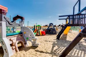 a playground in the sand with slides and swings at Hotel Blues in Cervia
