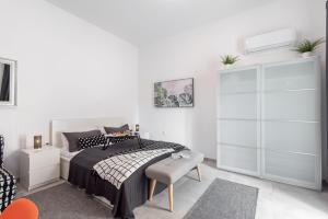 a white bedroom with a bed and a chair at Apartment Tara & Ana in Pula