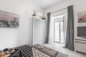 a white room with a bed and a television at Apartment Tara & Ana in Pula