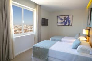 馬德里的住宿－Riu Plaza España，酒店客房设有两张床和窗户。