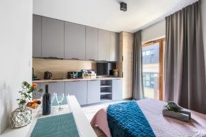 sypialnia z łóżkiem i stołem oraz kuchnia w obiekcie Studio Centrum Pawia Deluxe w Warszawie