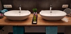 two white sinks on a wooden counter in a bathroom at Fewo Monika Mayr in Pfronten
