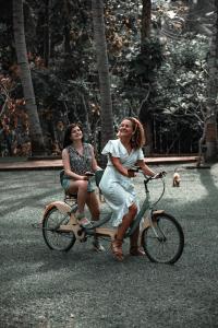 Zwei Frauen fahren Fahrrad auf der Straße in der Unterkunft Arika Villa in Dambulla