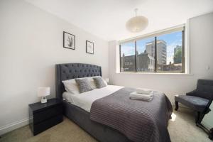 ロンドンにある2 Bed Cosy Apartment in Central London Fitzrovia FREE WIFI by City Stay Aparts Londonのベッドルーム1室(ベッド1台、窓、椅子付)