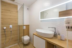 e bagno con lavandino, servizi igienici e doccia. di Apartmani Arapovic a Baška Voda