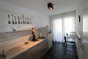 eine Küche mit einer Theke mit einer Spüle und einem Stuhl in der Unterkunft Park Linné Management GmbH in Köln