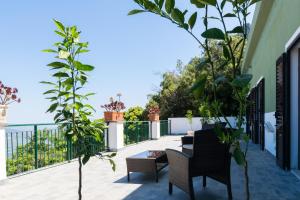 einen Balkon mit Stühlen, einem Tisch und Pflanzen in der Unterkunft S'Enis Monte Maccione in Oliena