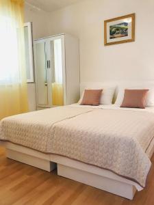 a bedroom with a large white bed in a room at Apartmani Jadera in Bol